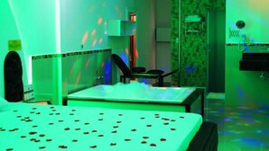 A hotel room with a bed, a desk, a chair, and a shower area. - Motel hotel Vitória  (Rialma)