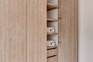 Ein Holzschrank mit mehreren Einlegeböden und einem kleinen Kleiderbereich.
