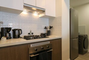 Een moderne keuken met een inbouwfornuis, oven en koelkast.
