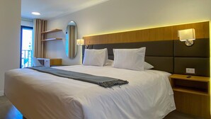 A hotel room with a large bed, a bedside table, a nightstand, a mirror, and a window with curtains. - w Luxury 3BR w Balcony in Upscale Miraflores (Lima)