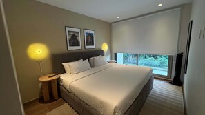 A hotel room with a large bed, two framed pictures on the wall, a bedside lamp, and a window with a view. - w Welcoming 2BR w Private Terrace in Hipodromo (Mexico City)