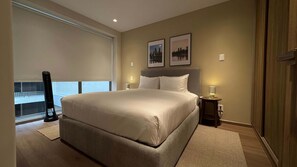 A bedroom with a large bed, a standing heater, a bedside table with a lamp, and a window with a view. - w Welcoming 2BR w Private Terrace in Hipodromo (Mexico City)