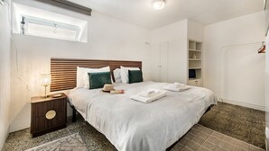 A bedroom with a bed, bedside table, lamp, and a window. - Casa M.V. Slater - CharmingTavira Townhouse with Rooftop Terrace (Pet friendly) (Tavira)