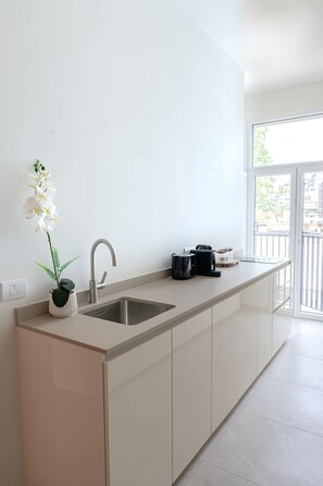 A modern kitchen with a sink, a coffee maker, and a potted orchid. - One Lux Stay 2br/2ba Antwerp Near Central Station (Antwerp)