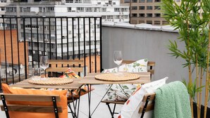 A balcony with a table set for two, featuring woven placemats and wine glasses. - One Lux Stay 3+1b2.5b Antwerp Near Central Station (Antwerp)
