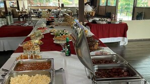 A buffet setup with various food items and utensils. - Pousada Village Da Serra (Santana do Riacho)