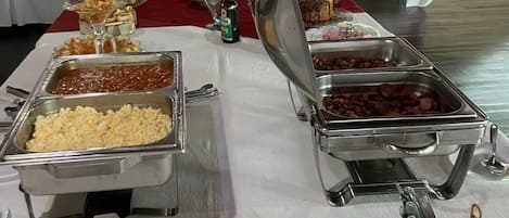 A buffet setup with various food items and utensils.