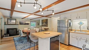 A modern kitchen with a central island, built-in appliances, and a rustic ceiling. - Lovely home walking distance to community beach sleeps 6 (Moultonborough)