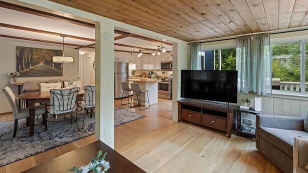 A spacious living area with a dining set, a kitchen, and a TV. - Lovely home walking distance to community beach sleeps 6 (Moultonborough)