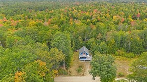 A house surrounded by a forest with autumn foliage. - Lovely home walking distance to community beach sleeps 6 (Moultonborough)