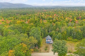 Ein Haus, umgeben von einem Wald mit Herbstlaub.