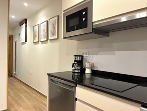 A modern kitchen with a dishwasher, a coffee maker, and a microwave. - Apartment in the Picos de Europa, Asturias. (Onis)