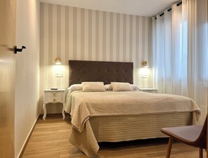 Une chambre à coucher avec un lit, des tables de chevet et une chaise.