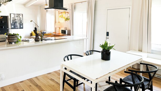 A modern kitchen with a central island, a dining area with a white table and black chairs, and a large window with curtains. - Perfect 3-bedroom townhome walking distance to Whole Foods in Santa Rosa (Santa Rosa)