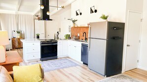 A modern kitchen with white cabinets, a black stove, and a refrigerator. - Perfect 3-bedroom townhome walking distance to Whole Foods in Santa Rosa (Santa Rosa)