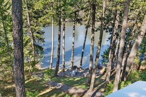 A forested area with tall trees and a body of water. - Charming Modern‑Rustic Retreat with a Chef’s Kitchen (Blanchard)