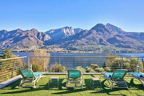 A terrace with lounge chairs overlooking a lake and mountains. - Villa Vittoria  (Oliveto Lario)