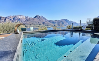 Una piscina con vistas a montañas y un lago.