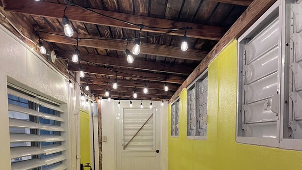 A hallway with a tiled floor, a wooden ceiling, and a door with a window. - Perfect Studio in the heart of Isabel! Walkable to all the bars and restaurants (Vieques)