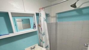 A bathroom with a toilet, sink, mirror, shower, and a tiled floor. - Perfect Studio in the heart of Isabel! Walkable to all the bars and restaurants (Vieques)