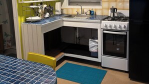 A compact kitchen with a sink, stove, and a window above the sink. - Perfect Studio in the heart of Isabel! Walkable to all the bars and restaurants (Vieques)
