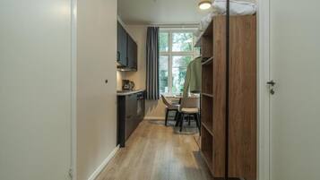 A narrow hallway with a kitchen area on one side and a dining area on the other.