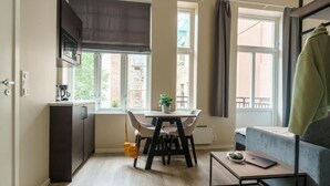 Un espacio habitable compacto con kitchenette, comedor y sofá.