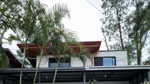 A two-story house with a stone facade, a gated entrance, and a balcony. - Balay Tori & Gil (Baguio)
