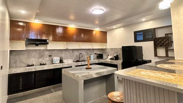 A modern kitchen with a central island, built-in appliances, and a bar area. - Balay Tori & Gil (Baguio)