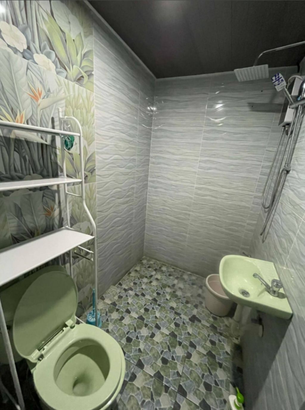 Een badkamer met toilet, wastafel en douche.