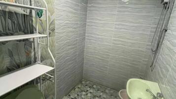 Een badkamer met toilet, wastafel en douche.