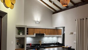 A modern kitchen with a central island, wooden cabinets, and pendant lighting. - Beachfront Apartment on the Upper Floor: Best Value for Money (Maraú)