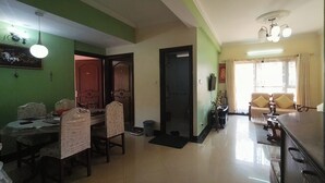 A dining area with a table and chairs, a sofa, and a television. - Metro axis residency (Kathmandu)