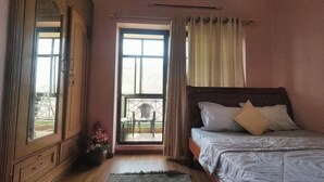 A bedroom with a wooden bed, a window with curtains, a balcony with a chair, and a wooden wardrobe. - Metro axis residency (Kathmandu)