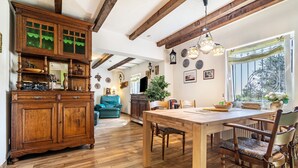 A spacious room with a wooden dining table, chairs, and a large cabinet.
