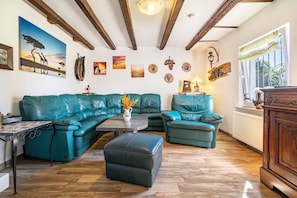 Ein Wohnzimmer mit einem Ecksofa, einem Couchtisch und einem Kamin.