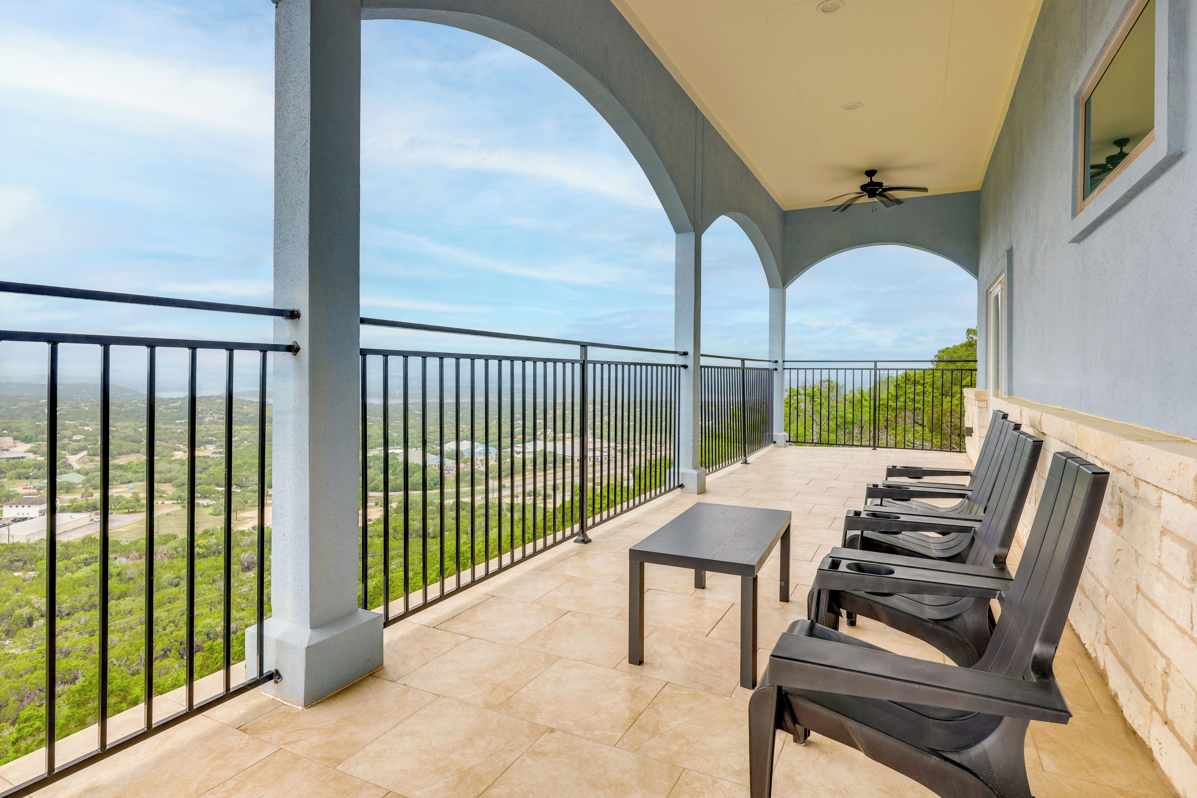 Uma varanda com vista para a paisagem, uma mesa e cadeiras.