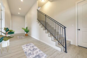 A staircase with a black railing, a wooden floor, and a white door. - Beautiful Lake Travis & Hill Country Views Home! (Leander)