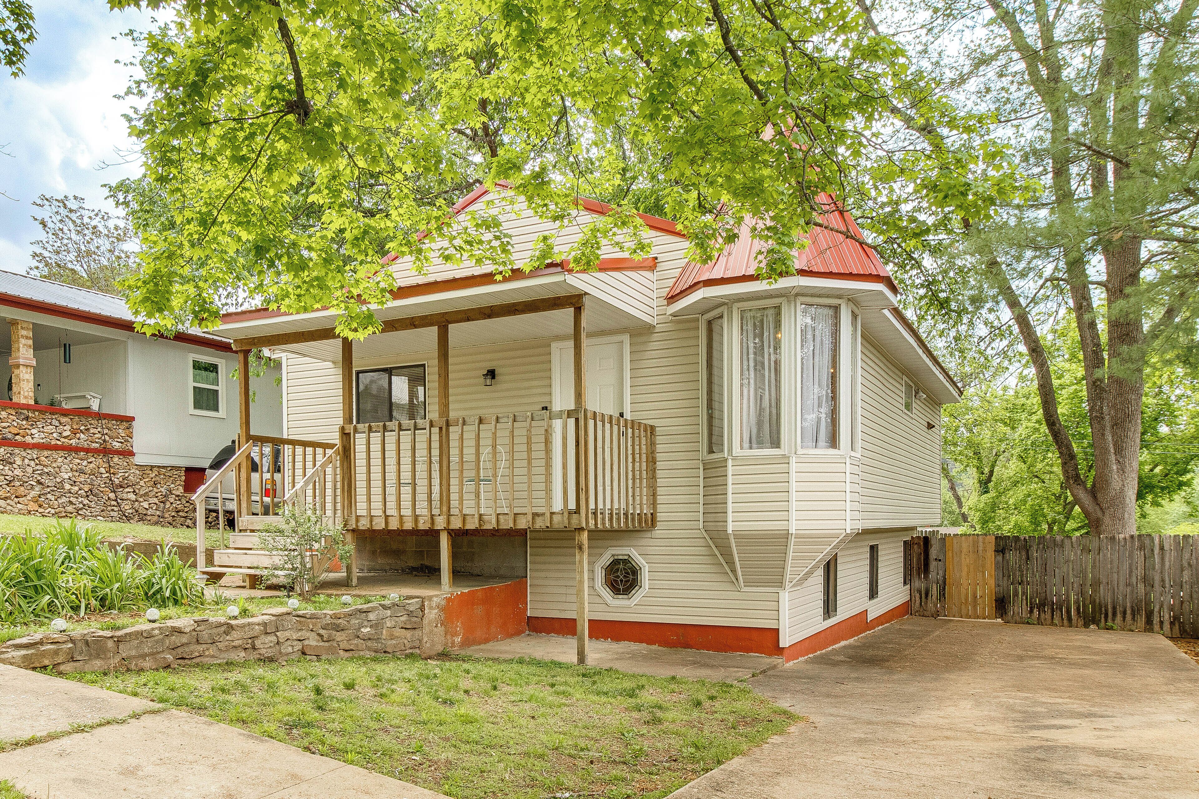 A single-story house with a porch, a small front yard, and a wooden fence.