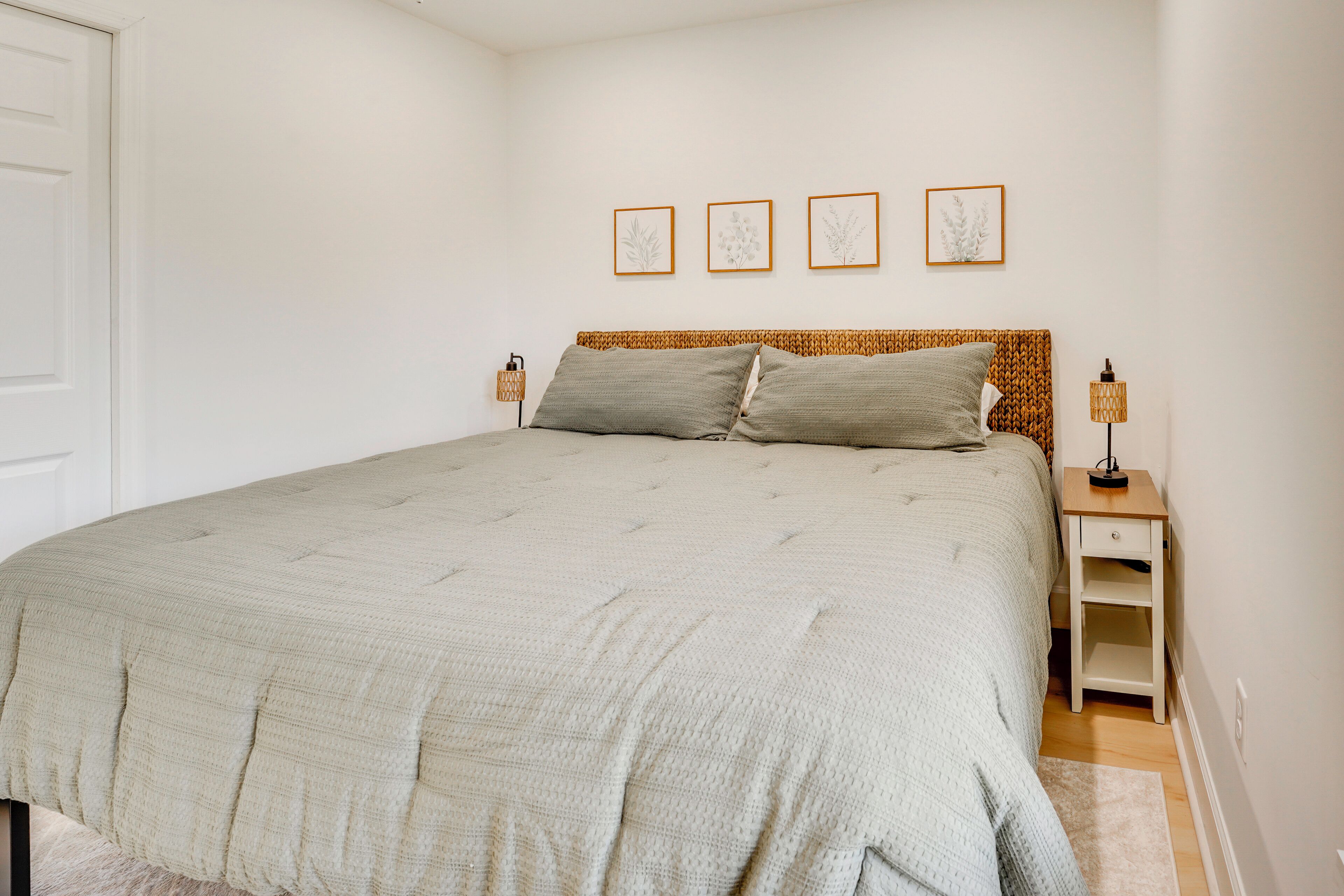Ein Schlafzimmer mit Bett, Nachttischen und einem Wandbild.