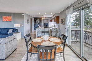 A dining area with a round table, chairs, and a view through a large glass door. - Working Farm w/ On-site Winery! Central Lake Hub (Central Lake)