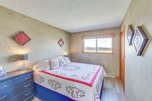 A bedroom with a bed, a dresser, a window, and decorative wall art. - Working Farm w/ On-site Winery! Central Lake Hub (Central Lake)