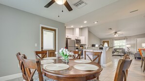 A dining area with a round table, chairs, and a vase of flowers. - Central Florida Retreat Near The Villages & Golf! (Summerfield)