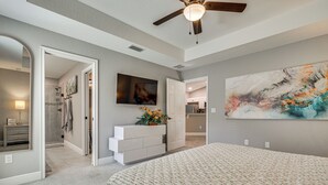 A bedroom with a bed, a ceiling fan, a dresser, a TV, and a painting. - Central Florida Retreat Near The Villages & Golf! (Summerfield)