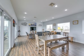 A spacious living area with a wooden dining table, a sofa, and a television. - 2 Oceanfront Homes w/ Surfside Beach Access! (Freeport)