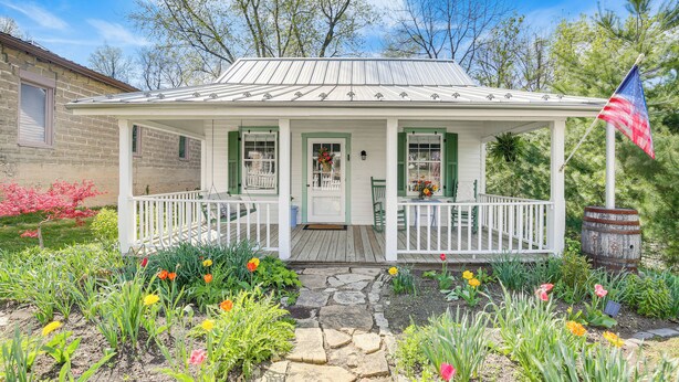 A white house with a porch, green shutters, and a flag. - Walk to Wineries: Charming Retreat in Augusta! (Augusta)