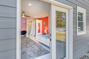 A bedroom with a bed, a nightstand, a lamp, and a window. - Explore Atl! Cozy Couple's Hideaway in Ellenwood (Ellenwood)