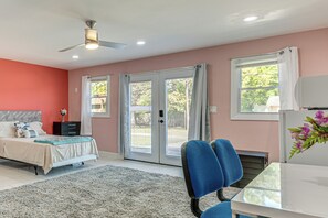 A bedroom with a bed, a desk, a chair, a ceiling fan, and a window with curtains. - Explore Atl! Cozy Couple's Hideaway in Ellenwood (Ellenwood)