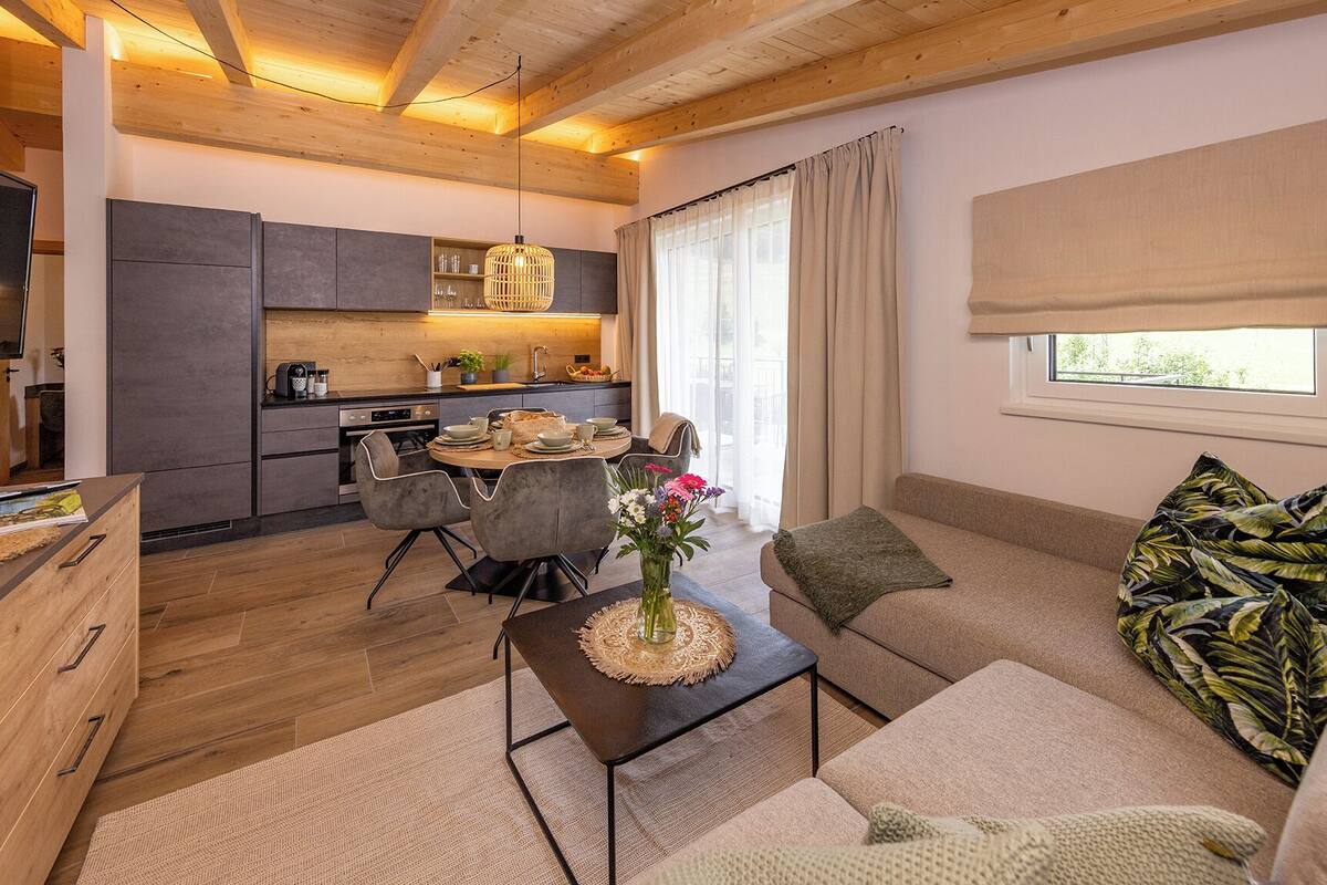 Una sala de estar moderna con sofá, mesa de centro y comedor.
