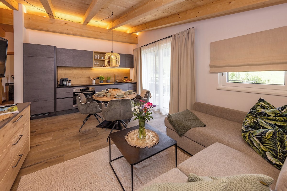 A modern living room with a sofa, coffee table, and dining area.